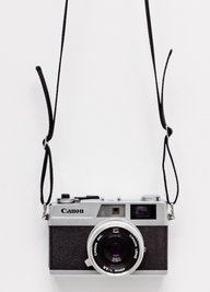 En gammaldags Canon kamera med långa remmar.